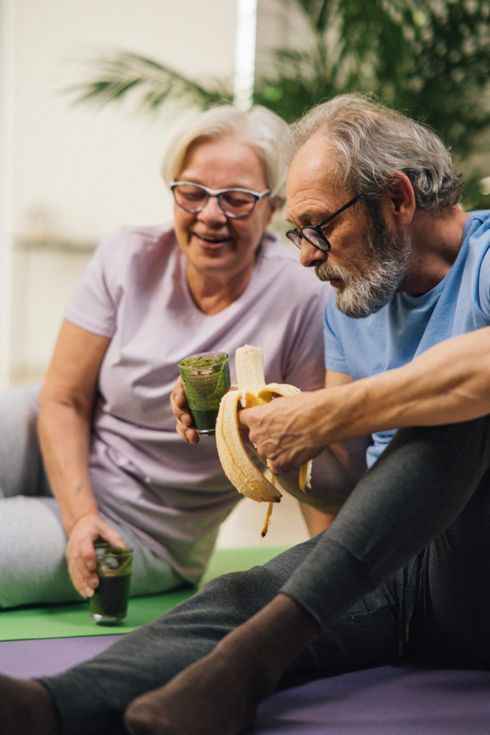pexels-photo-6974995-6974995 Elderly man and woman sharing a healthy snack while relaxing indoors, promoting a healthy lifestyle.